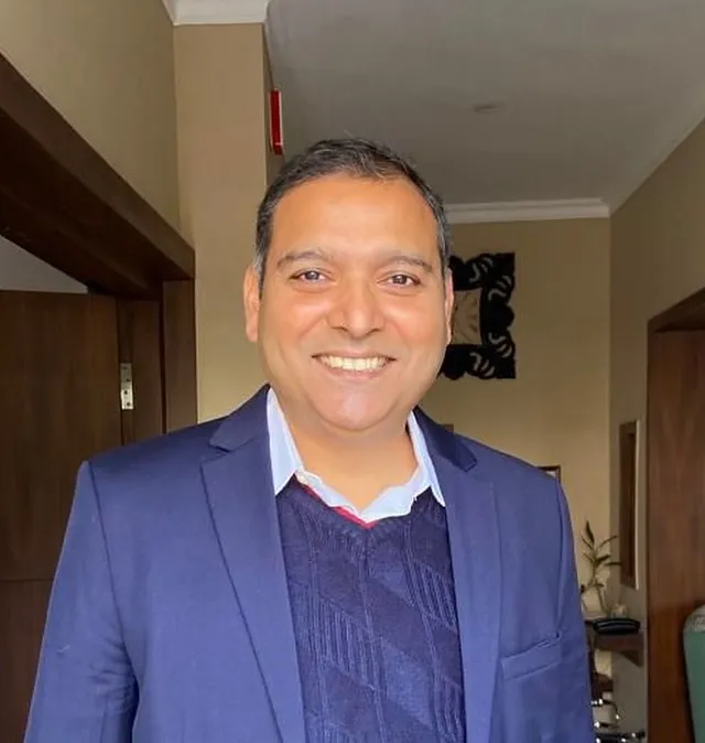 Vikas Khanduri, Managing Director of Viva Voyages, smiling in a navy blazer