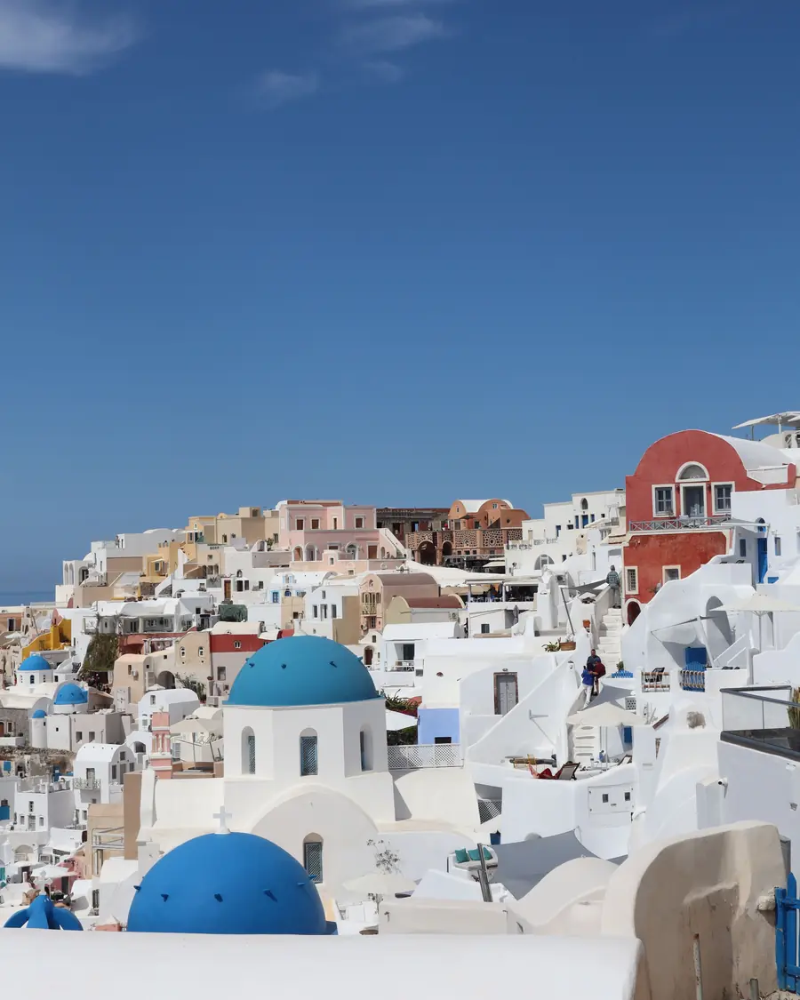 Blue-domed churches and white houses on the cliff at Oia, Santorini