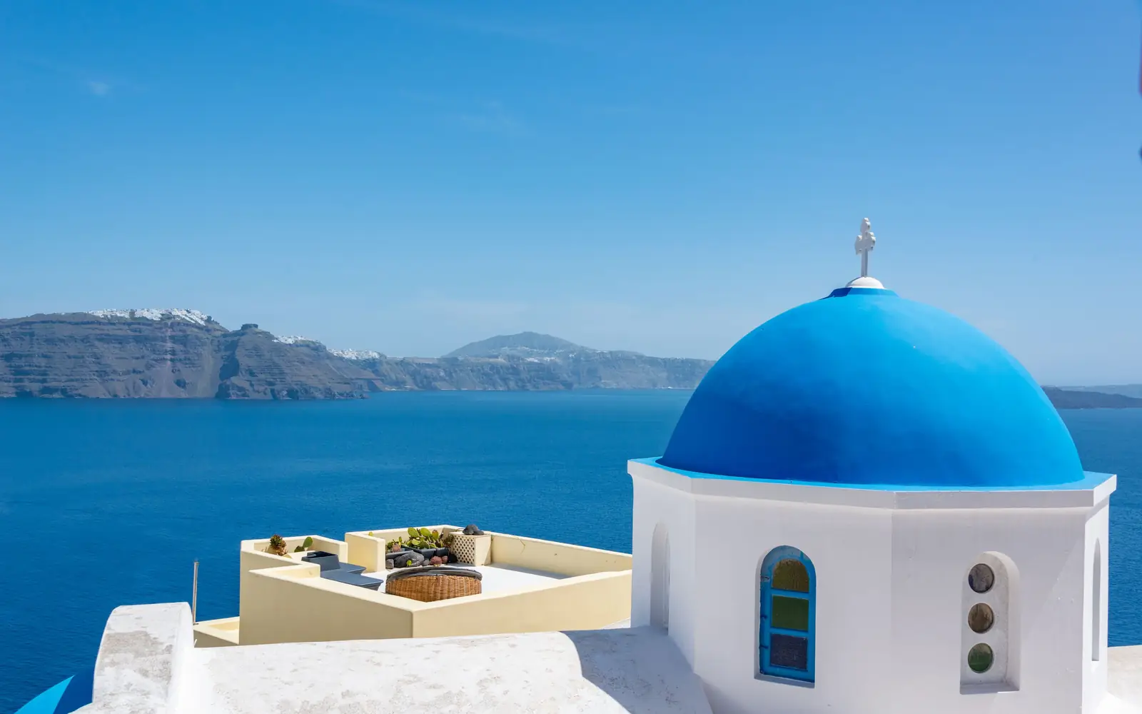 A blue church dome above the caldera at Santorini, Greece