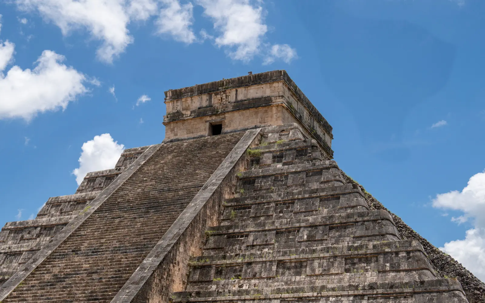 The stepped pyramid of El Castillo at Chichén Itzá under white clouds, Mexico
