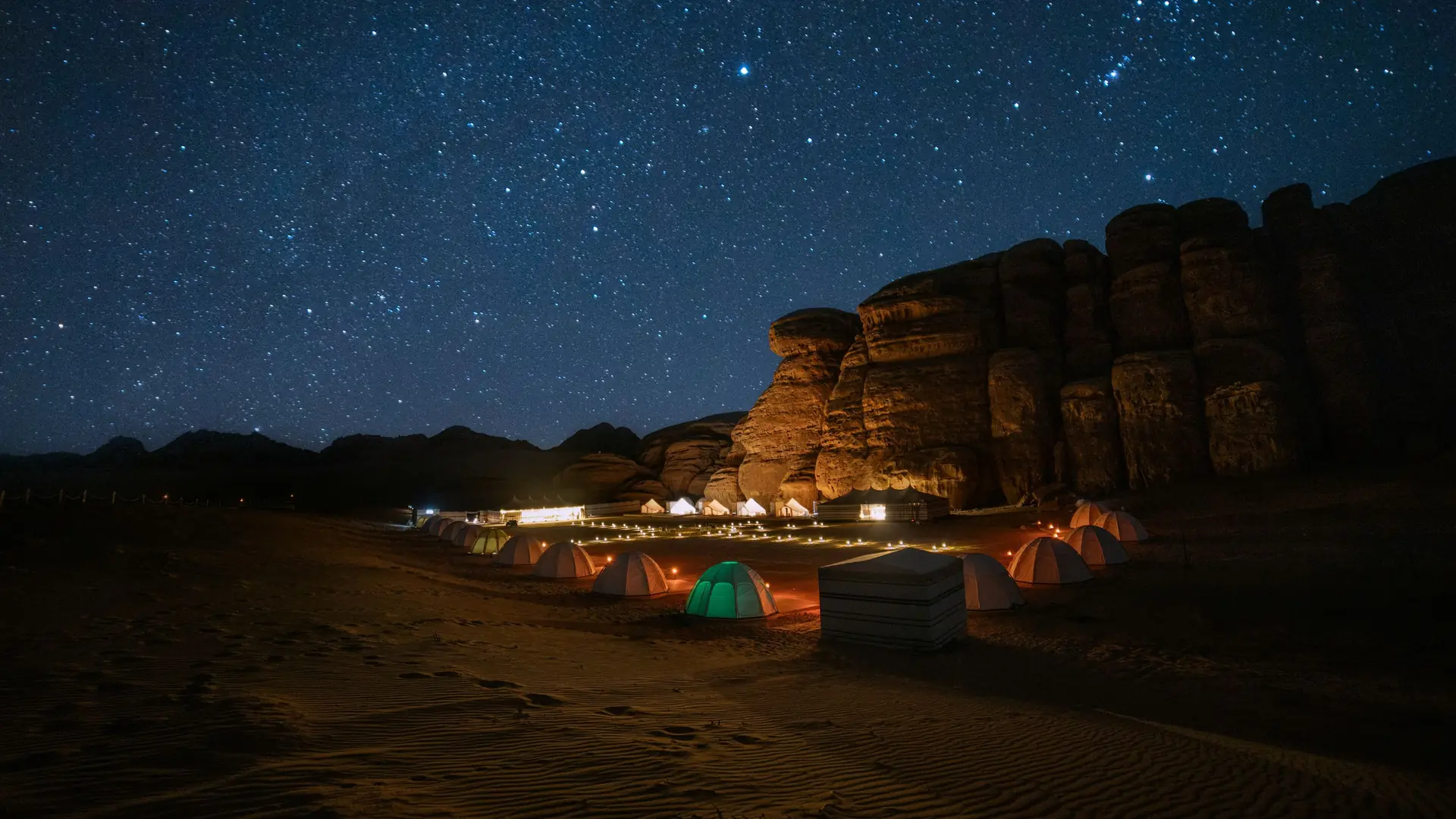 A desert camp glowing under a sky full of stars near AlUla, Saudi Arabia